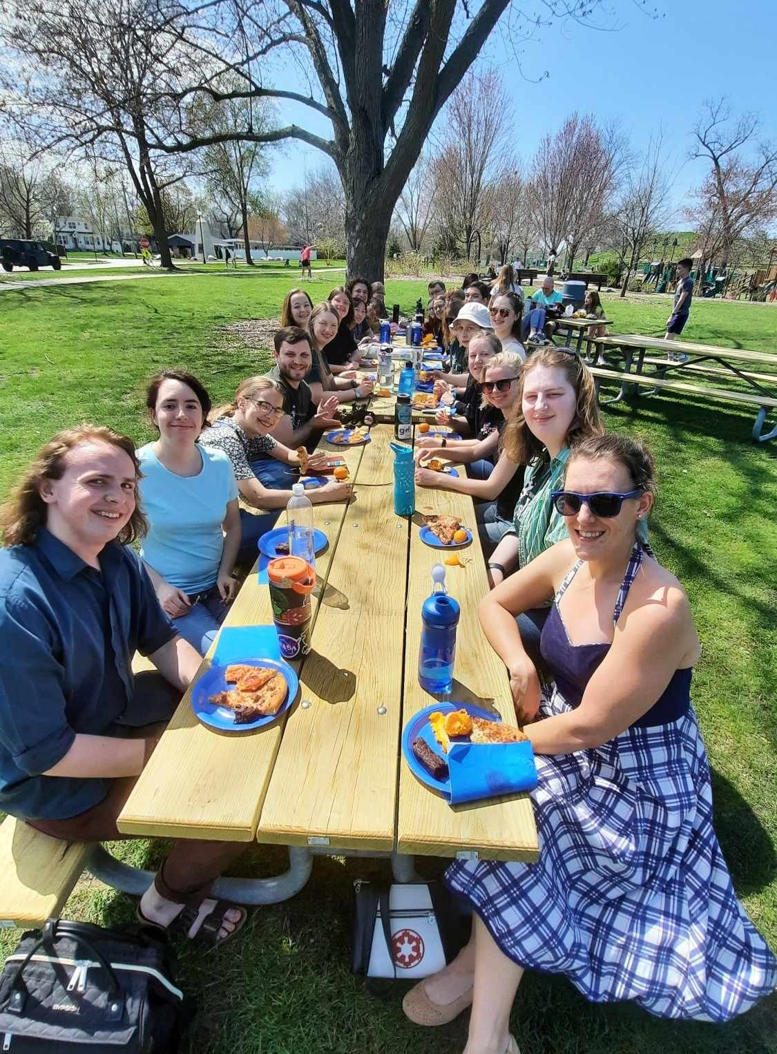 People sitting at a long picnic table