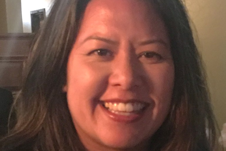 A dark-haired Asian woman smiles