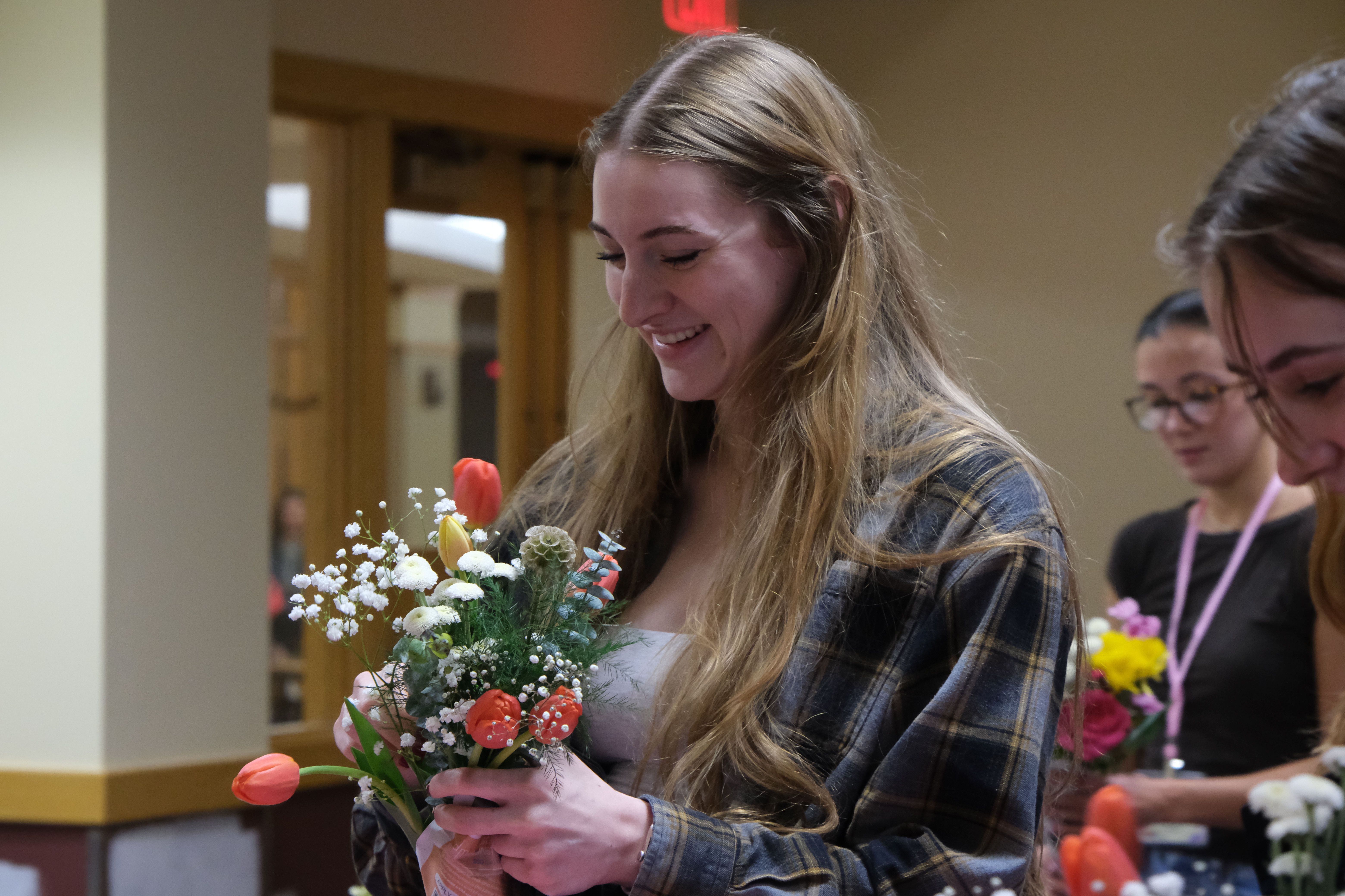 Female student smiling while making floral arrangement