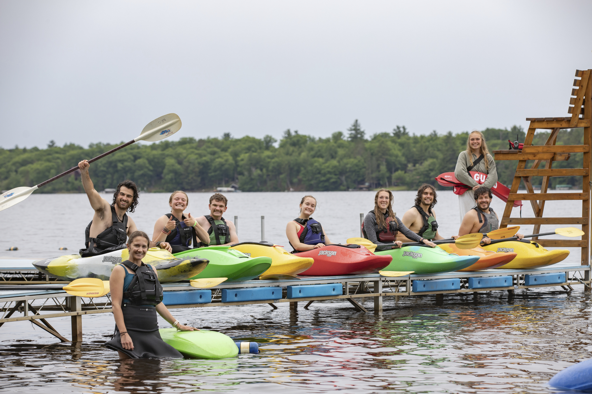 A line of college students in kayaks on the lake