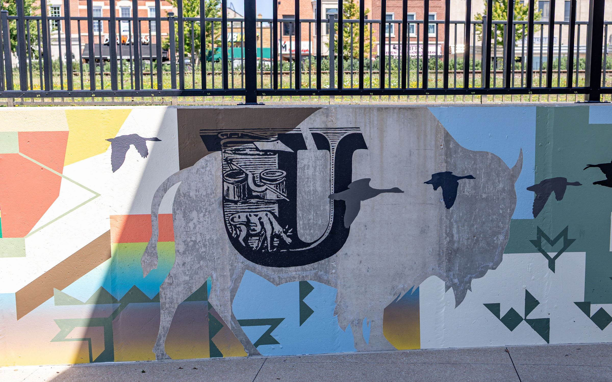A buffalo is depicted in a painting on an outdoor wall.
