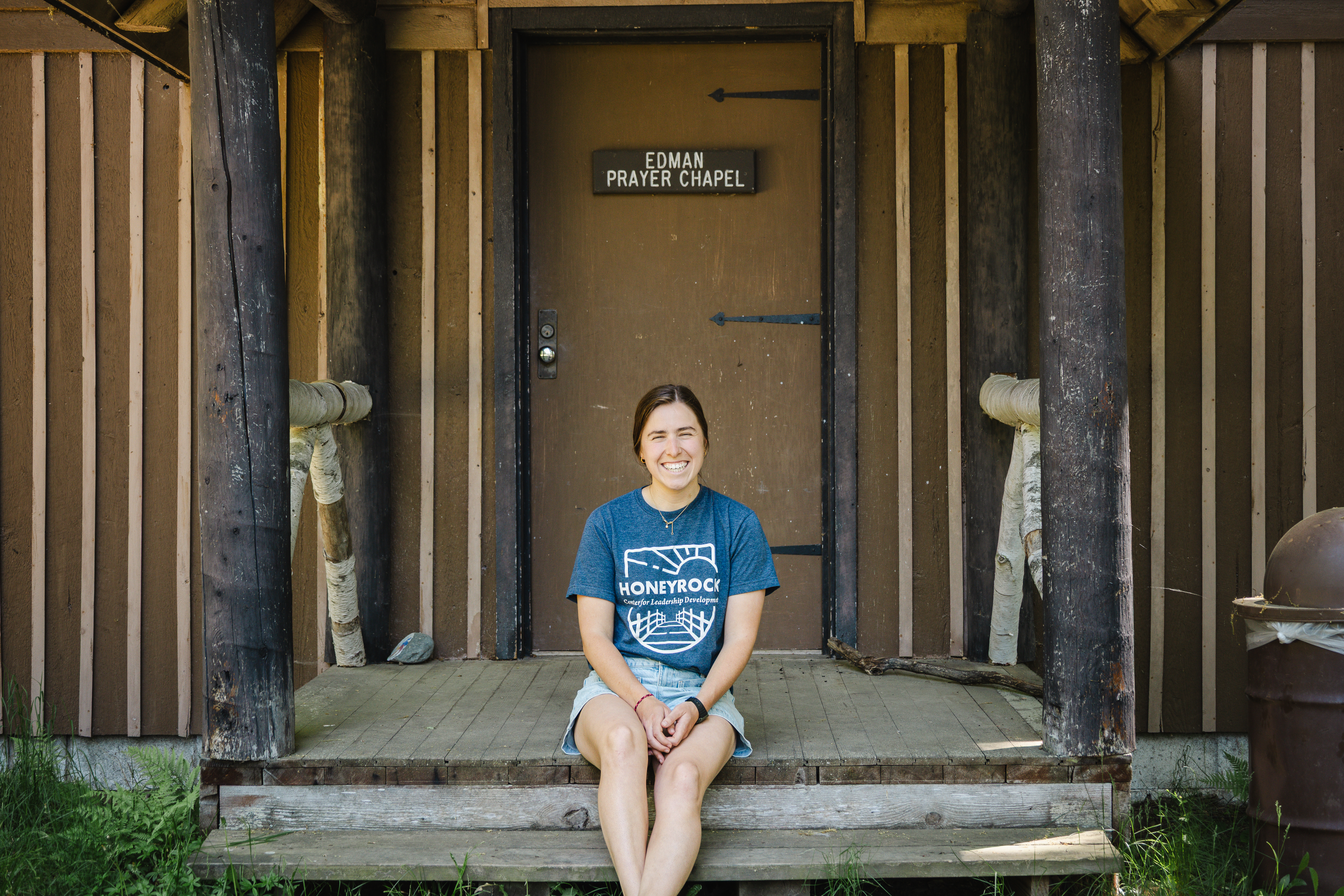 A young women sitting infront of the prayer chapel wearing a honeyrock shirt