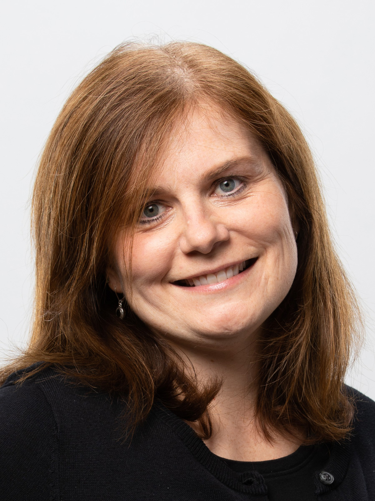 A ginger-haired woman wearing black smiles A ginger-haired woman wearing black smiles