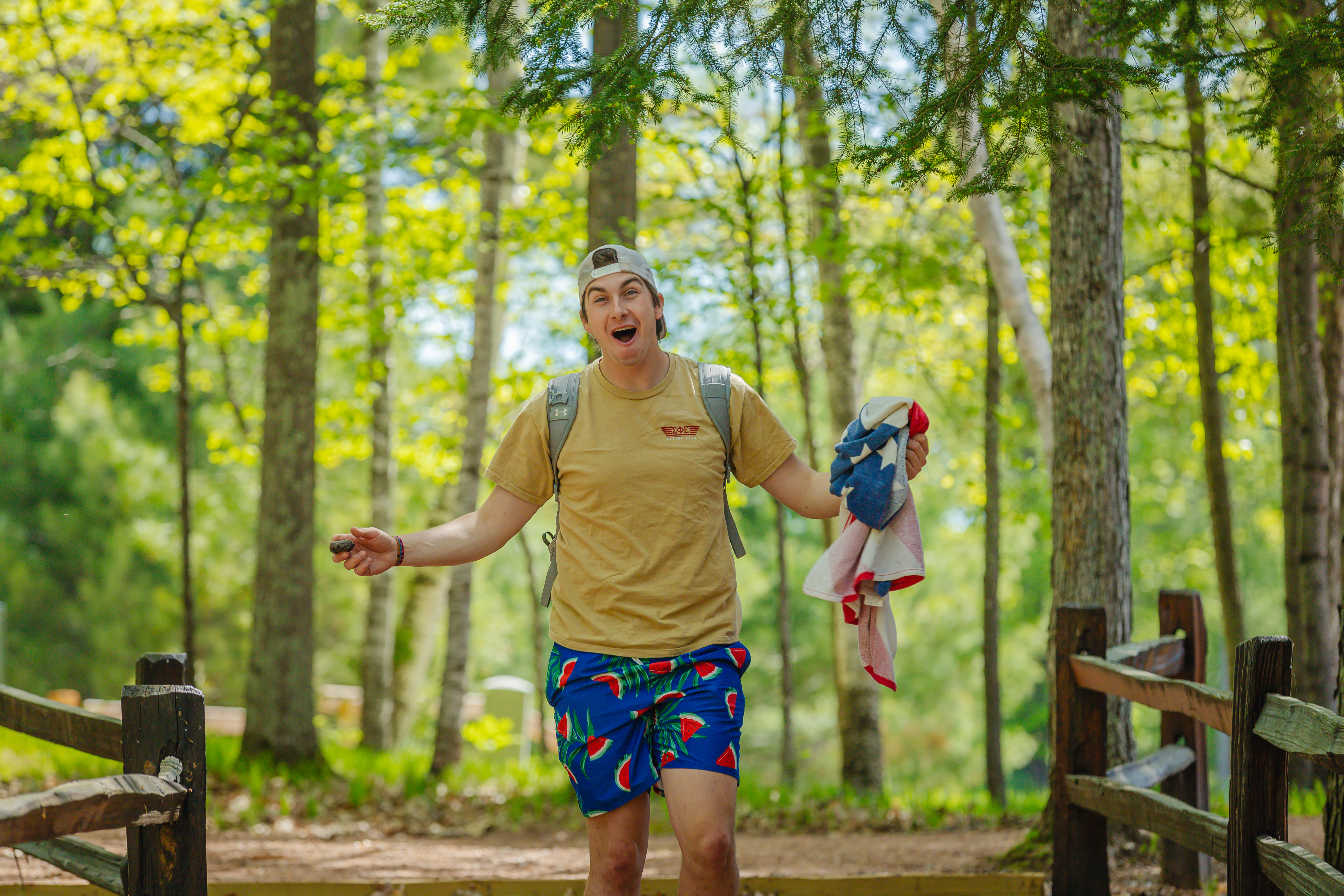 A college student smiling in the woods