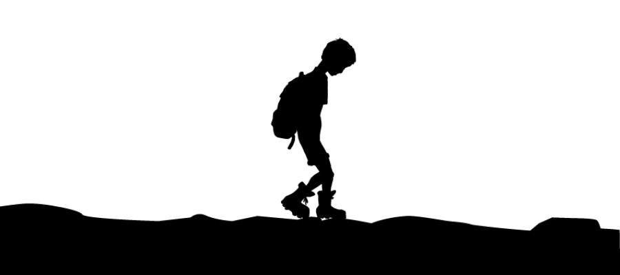 Silhouette of a boy walking with a backpack on uneven ground