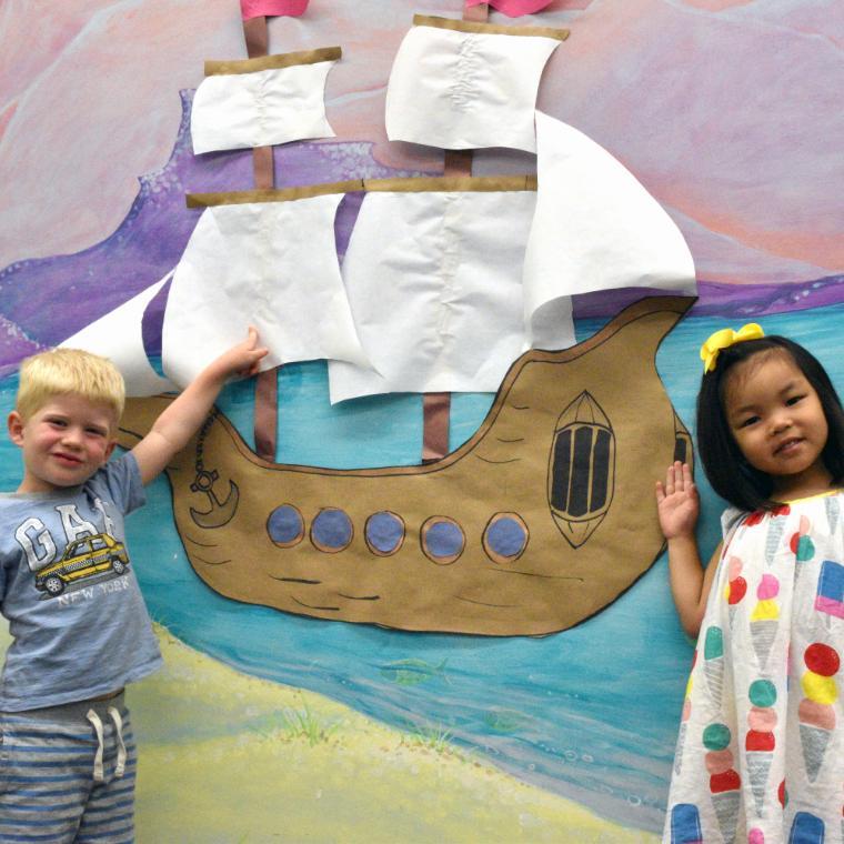 ec students pointing to paper boat