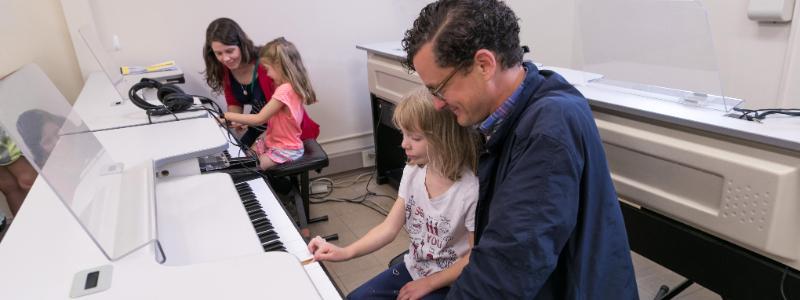 Mr. Milliner and child at keyboard