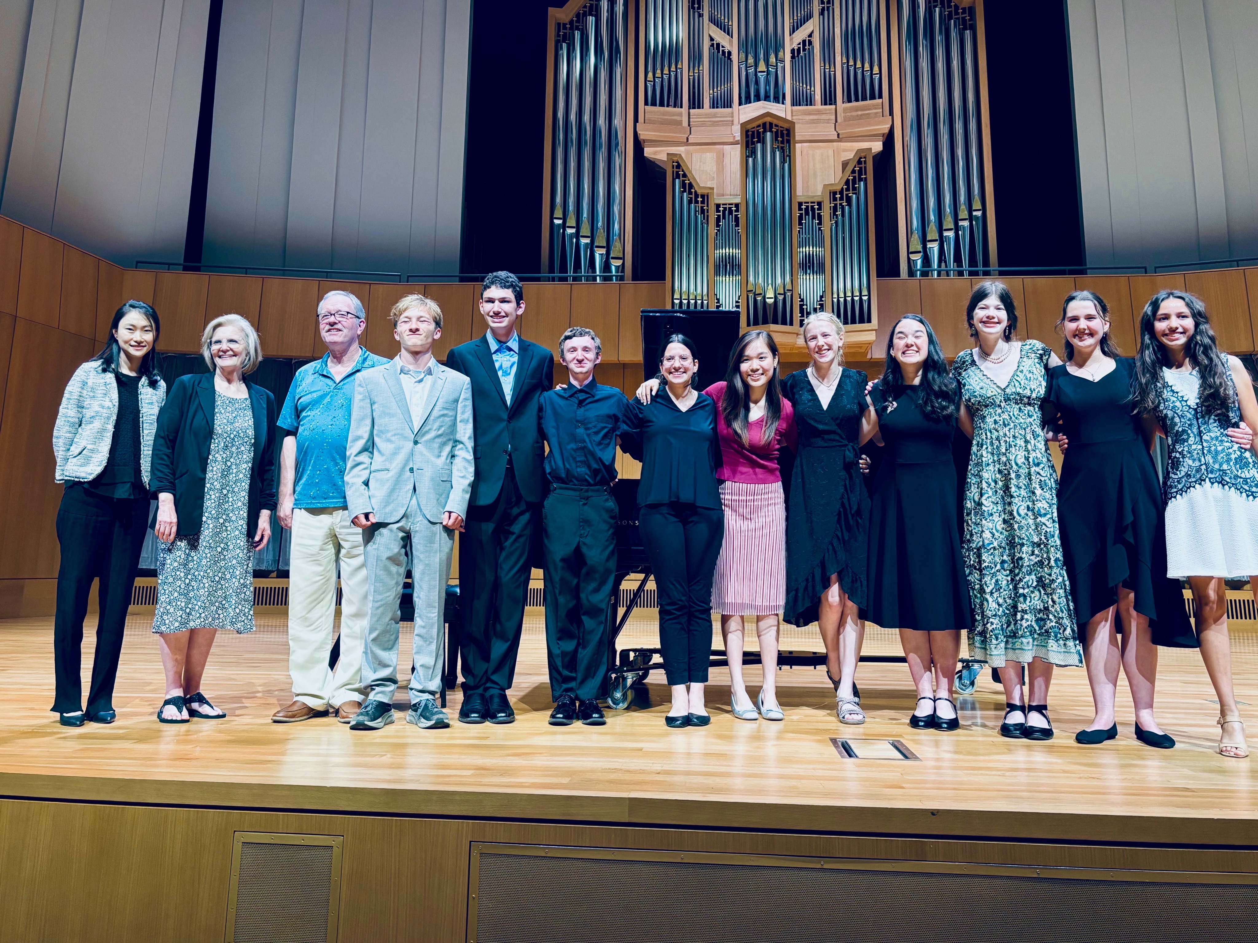 Professors stand with students on the edman chapel stage