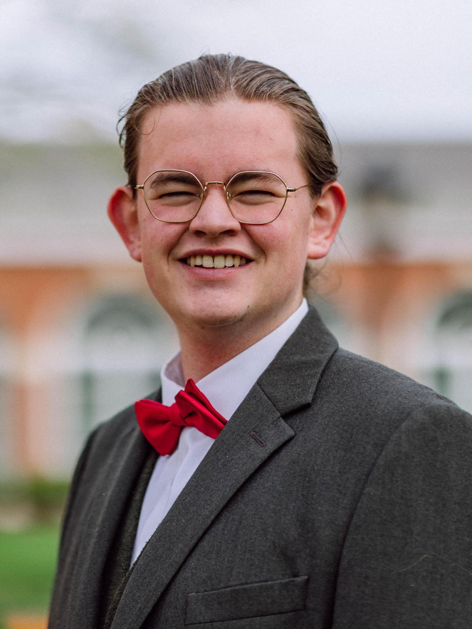 A young white male with brown hair smiles
