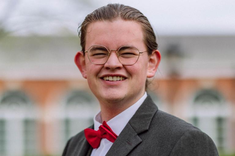 A young white male with brown hair smiles
