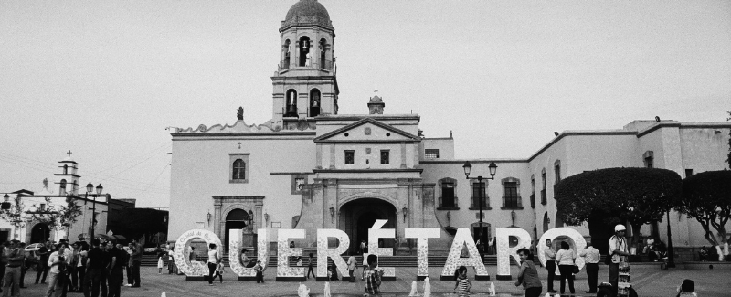 Queretaro central plaza, large letters spelling Queretaro in front of historic building.