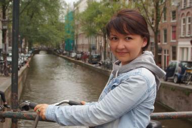 Jenya Fazletinova standing by the river and smiling