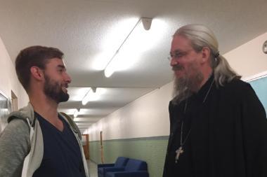 two men standing together and speaking