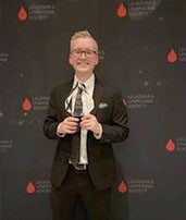 male student holding award