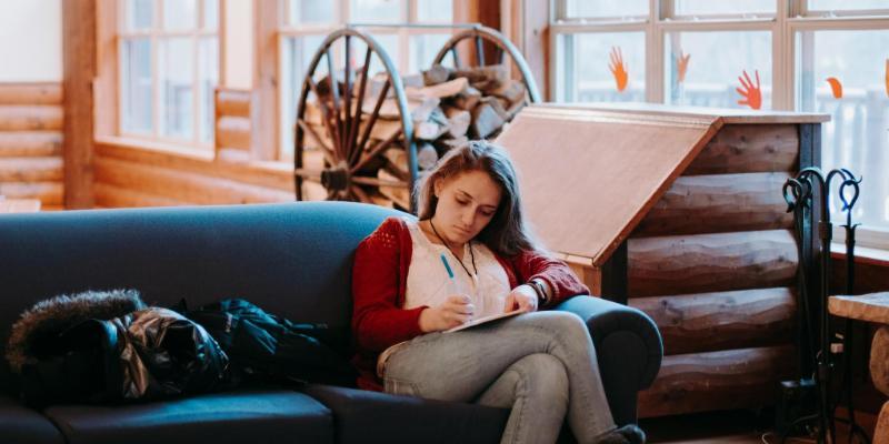 kyra journaling on a couch