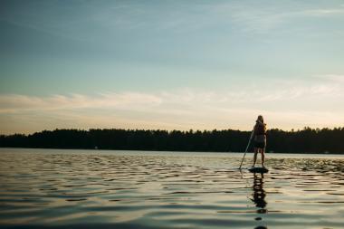 Girl paddleboarding at sunset