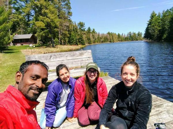 Graduate students sitting by river near HoneyRock