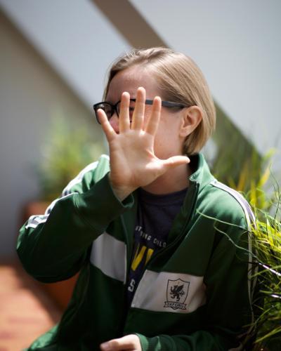 Photo of a student laughing and holding her hand in front of her face