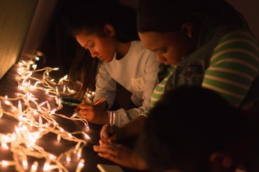 Students writing Letters by Christmas Lights