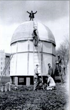 5 men standing by and on top of observatory building