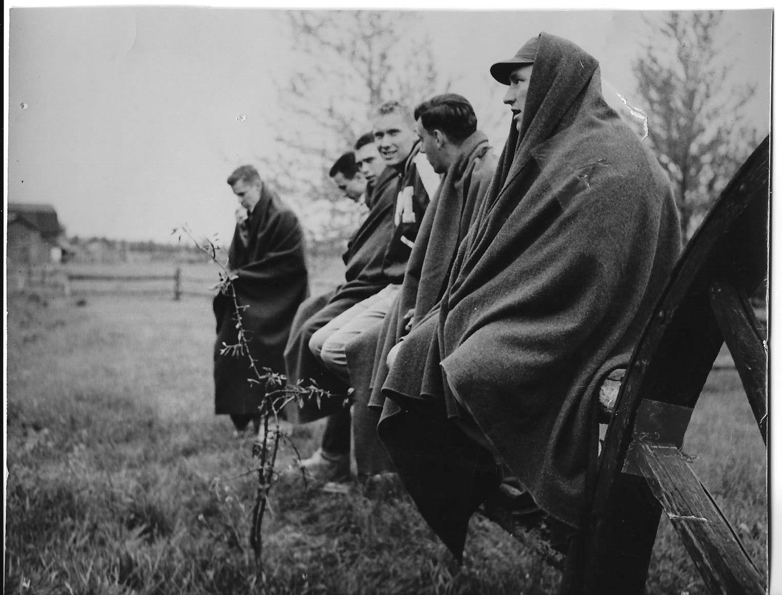 Jerry Snyder, Karl Johnson, Ed Olsen, Ed Davies, Ted Dyrness, and Milt Revere sitting on a fence post