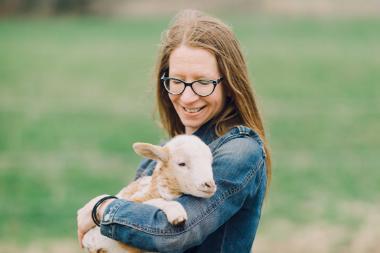 Wheaton College IL English professor Dr. Tiffany Kriner holding a lamb at Root and Sky Farm