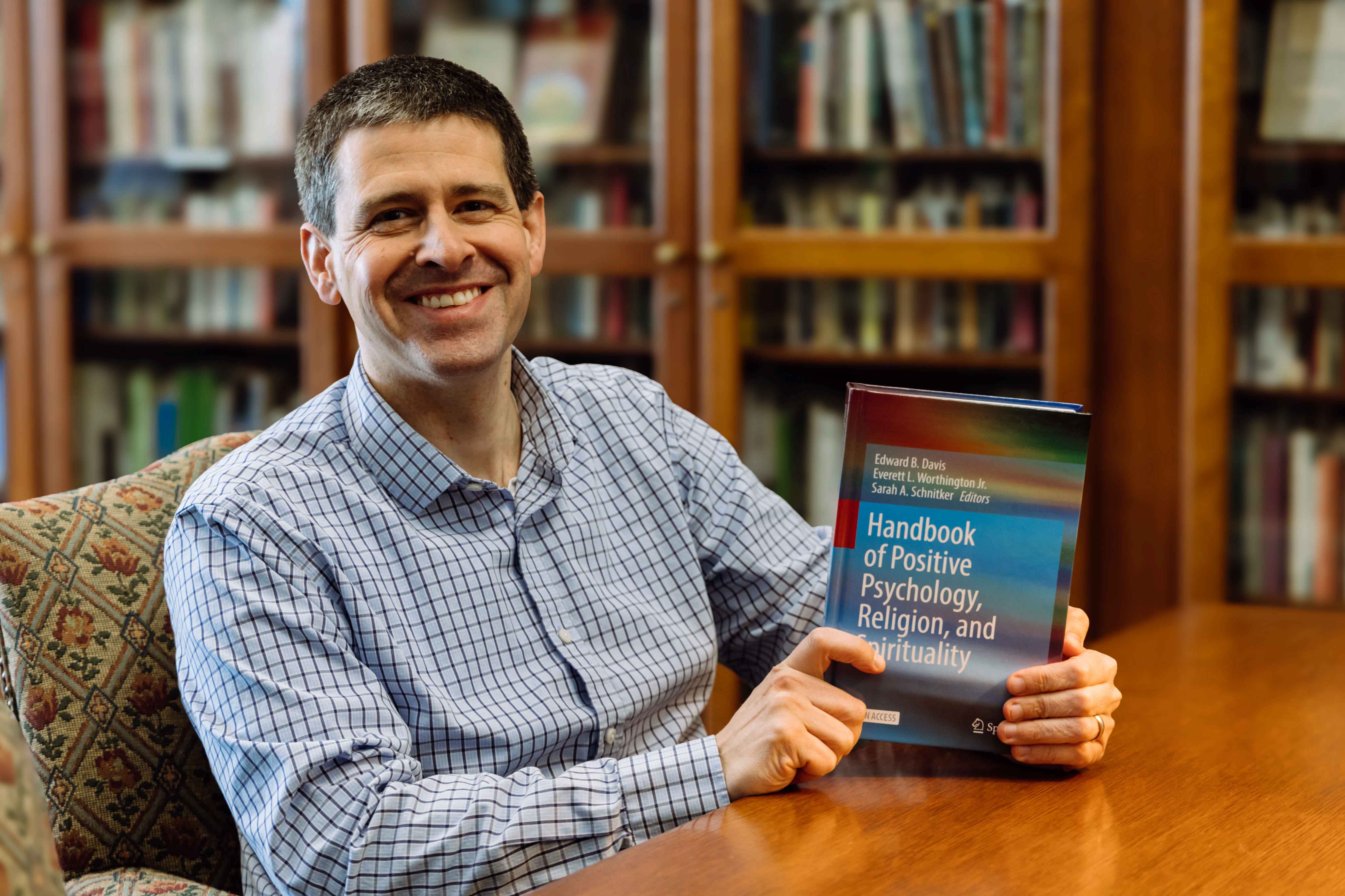 Wheaton College IL Dr. Ward Davis in the Wade Center with the textbook he helped write