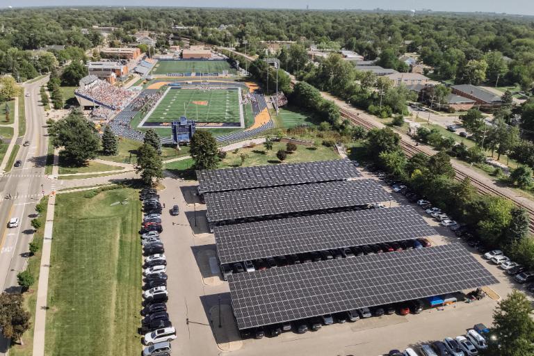 Overhead drone view of completed solar panels in Wheaton parking lot next to football field