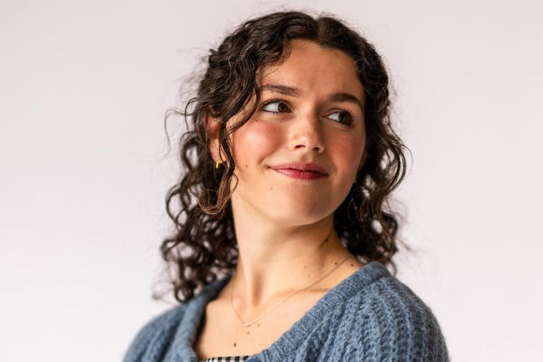 Doctoral student wearing a blue sweater and black and white gingham dress - Wheaton College Graduate School Bible and Theology Program