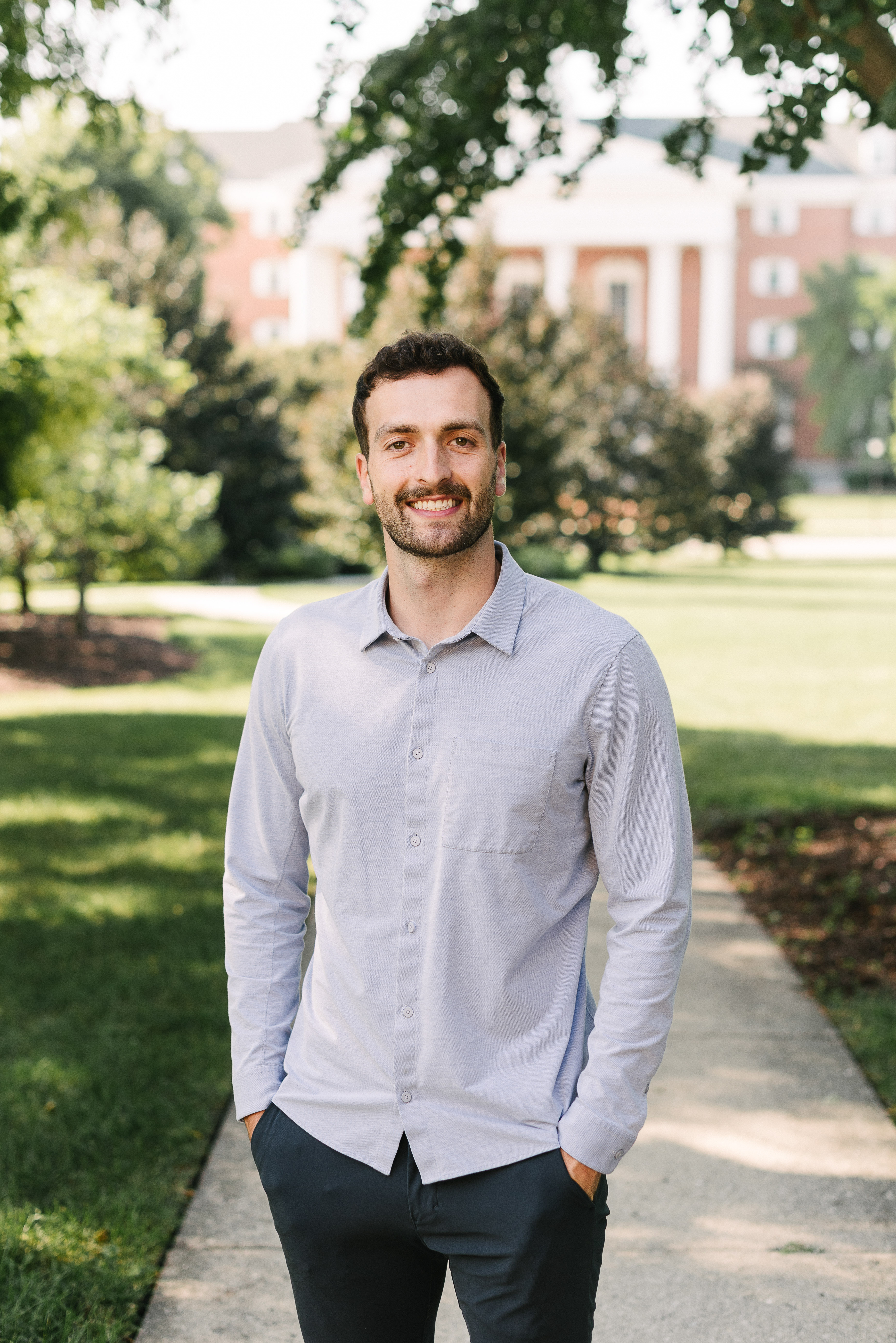 Man in button down shirt standing with Billy Graham Hall in the background