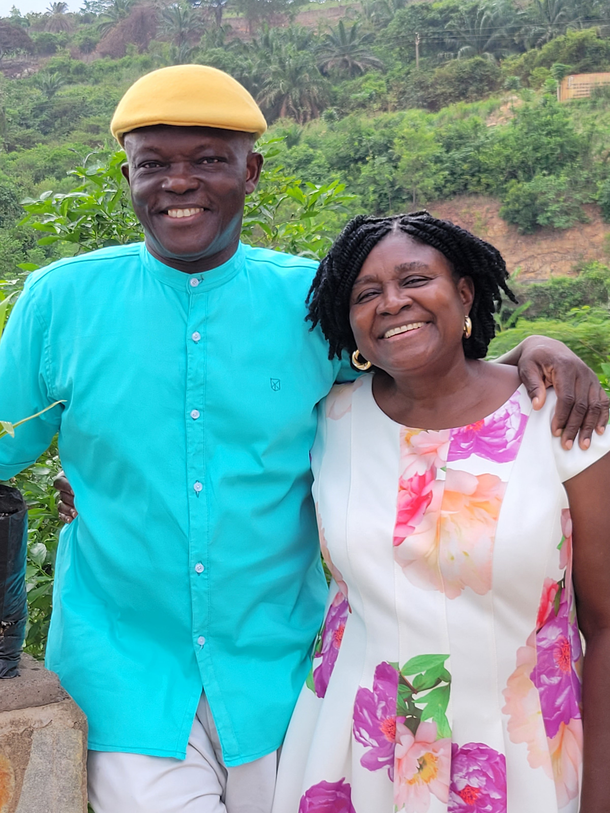 An African man and an African woman stand together and smile