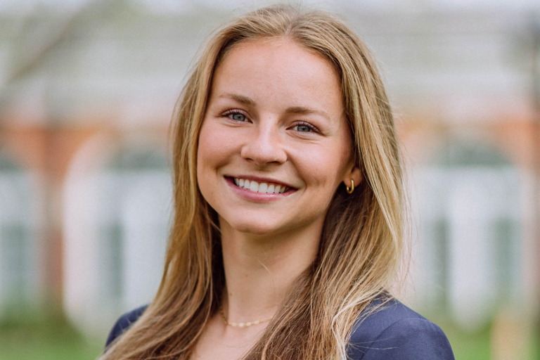 A white blonde young woman smiles