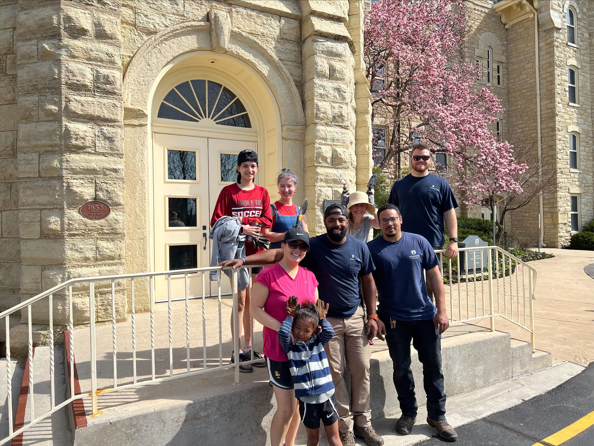 Volunteers pose with Landscape Operations staff outside Blanchard Hall