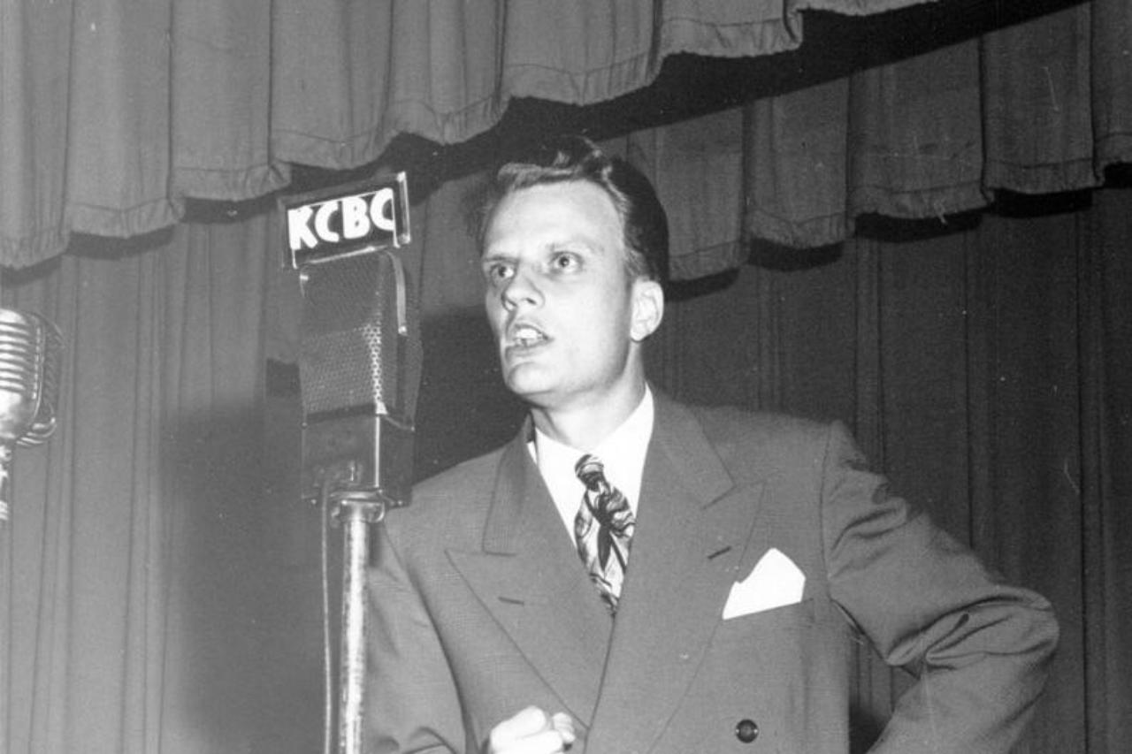 Billy Graham preaches over the radio