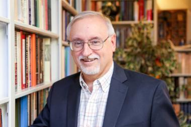 Dr. John Walton in front of books 380x253