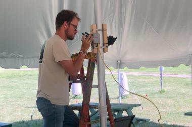 Wheaton Student Installing Solar Panel in Tent