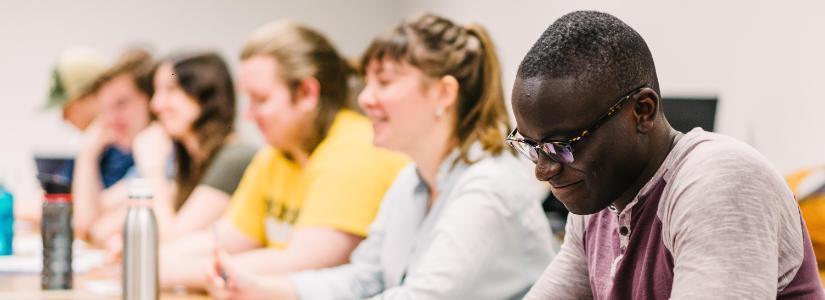 Students sitting at table while in class 825 x 300