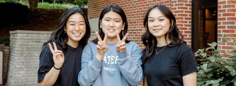 Three female students displaying peace sign 825 x 300 