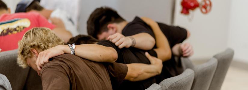 Three male students praying together 825 x 300 